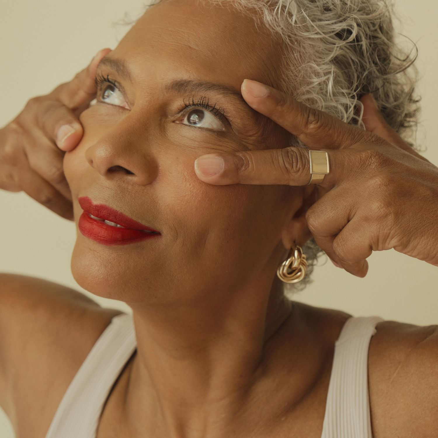 Smiling woman playfully posing with her hands.