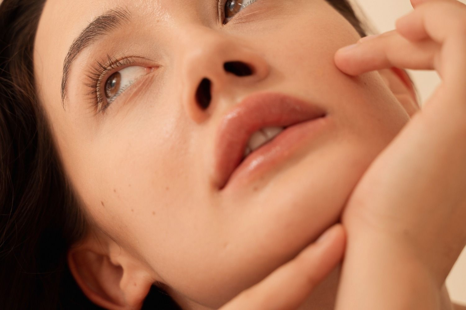 Close-up of a woman’s face and hand.