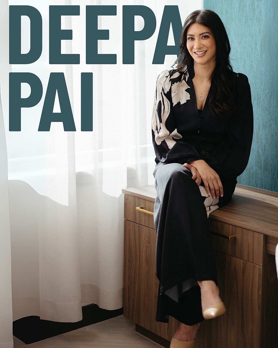 Woman sitting elegantly in a stylish outfit.