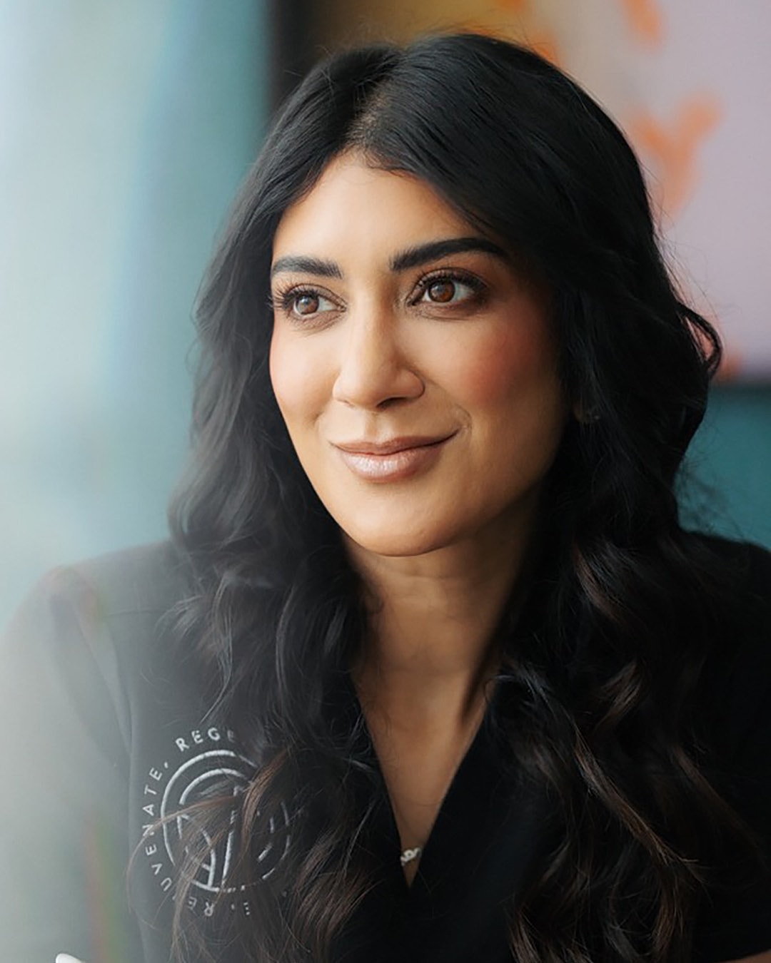 Professional woman with long, dark hair smiling.