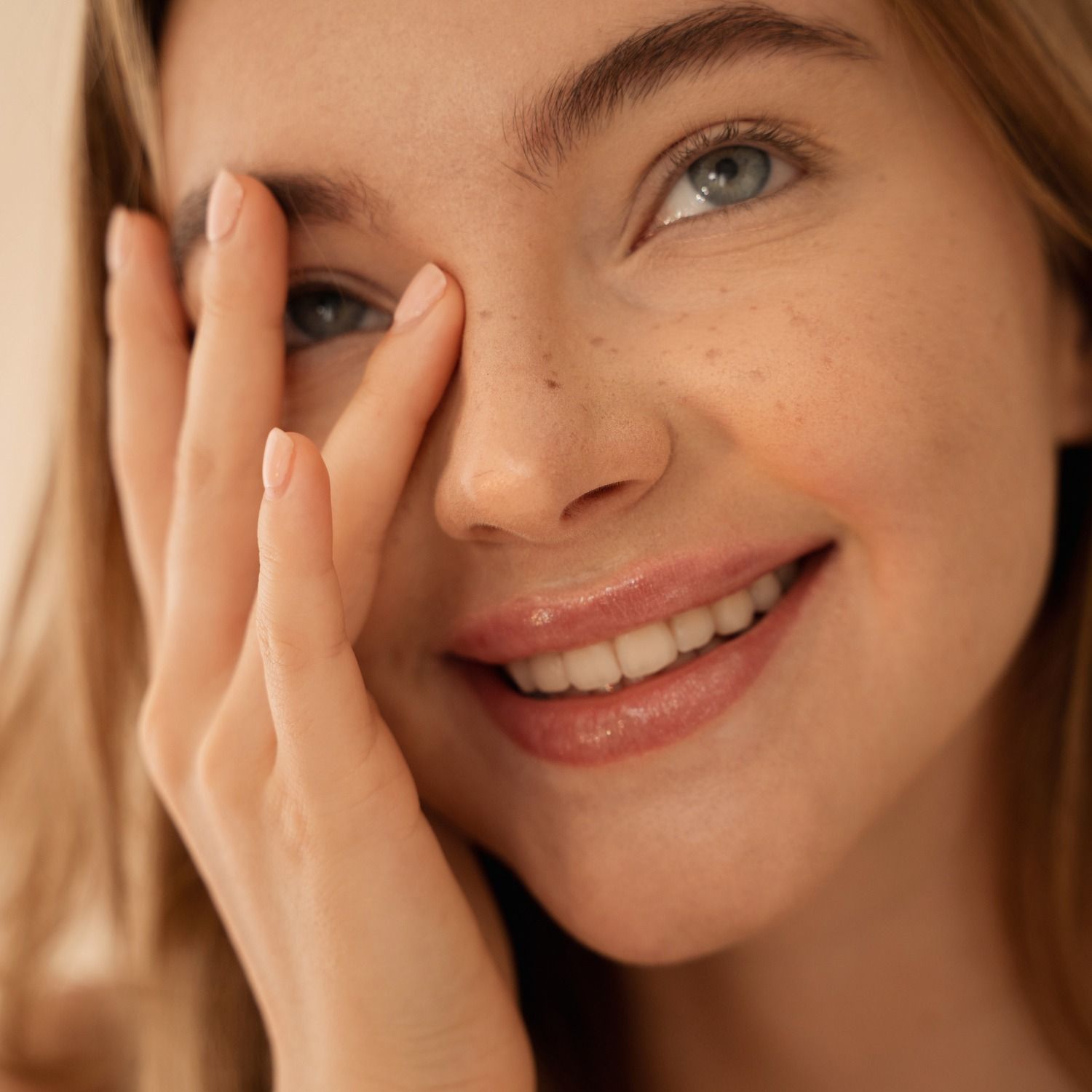 Smiling woman playfully touching her face.