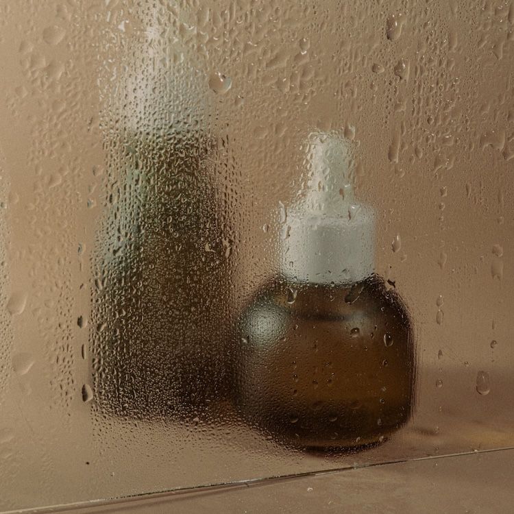 Glass bottles behind a fogged-up surface.