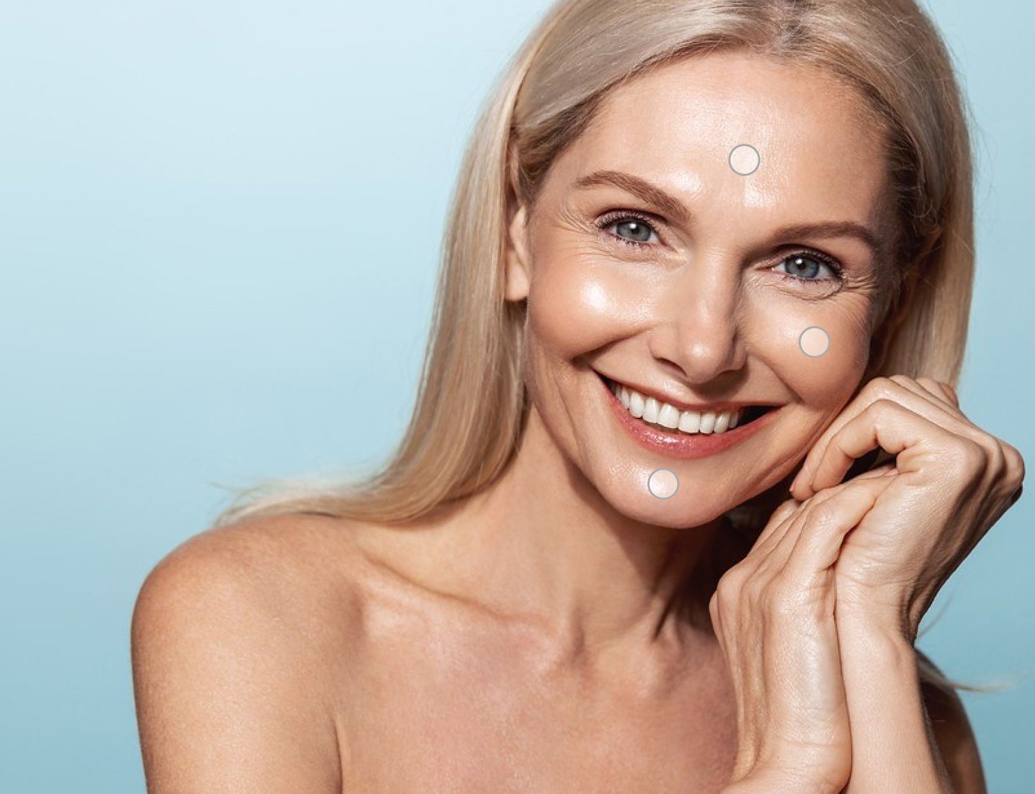 Smiling woman with blonde hair and clear skin.