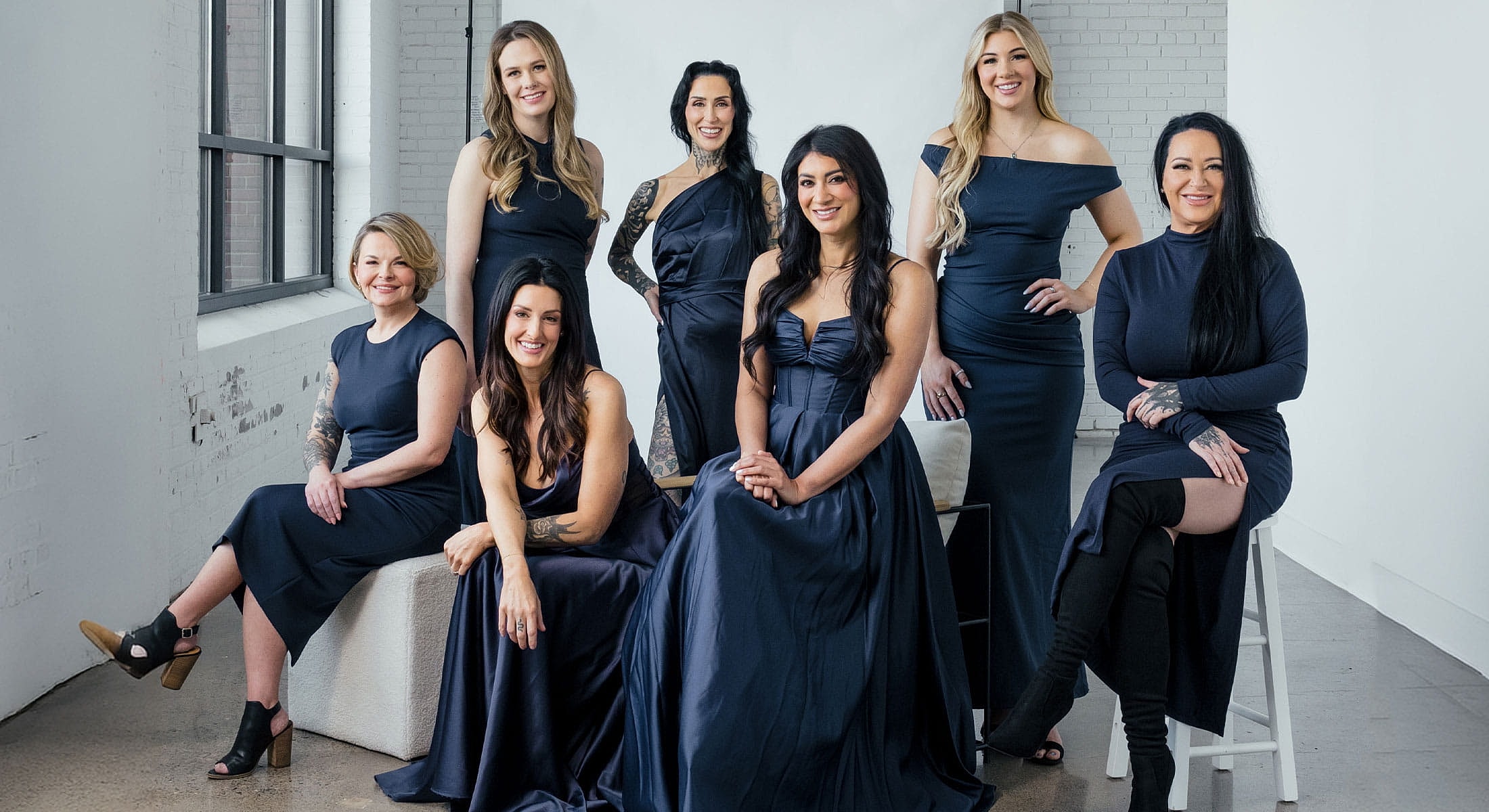 Group of women in elegant navy dresses.