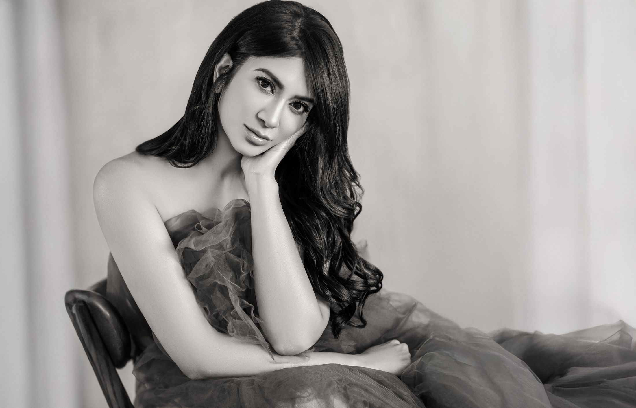 Woman in elegant pose wearing soft fabric.