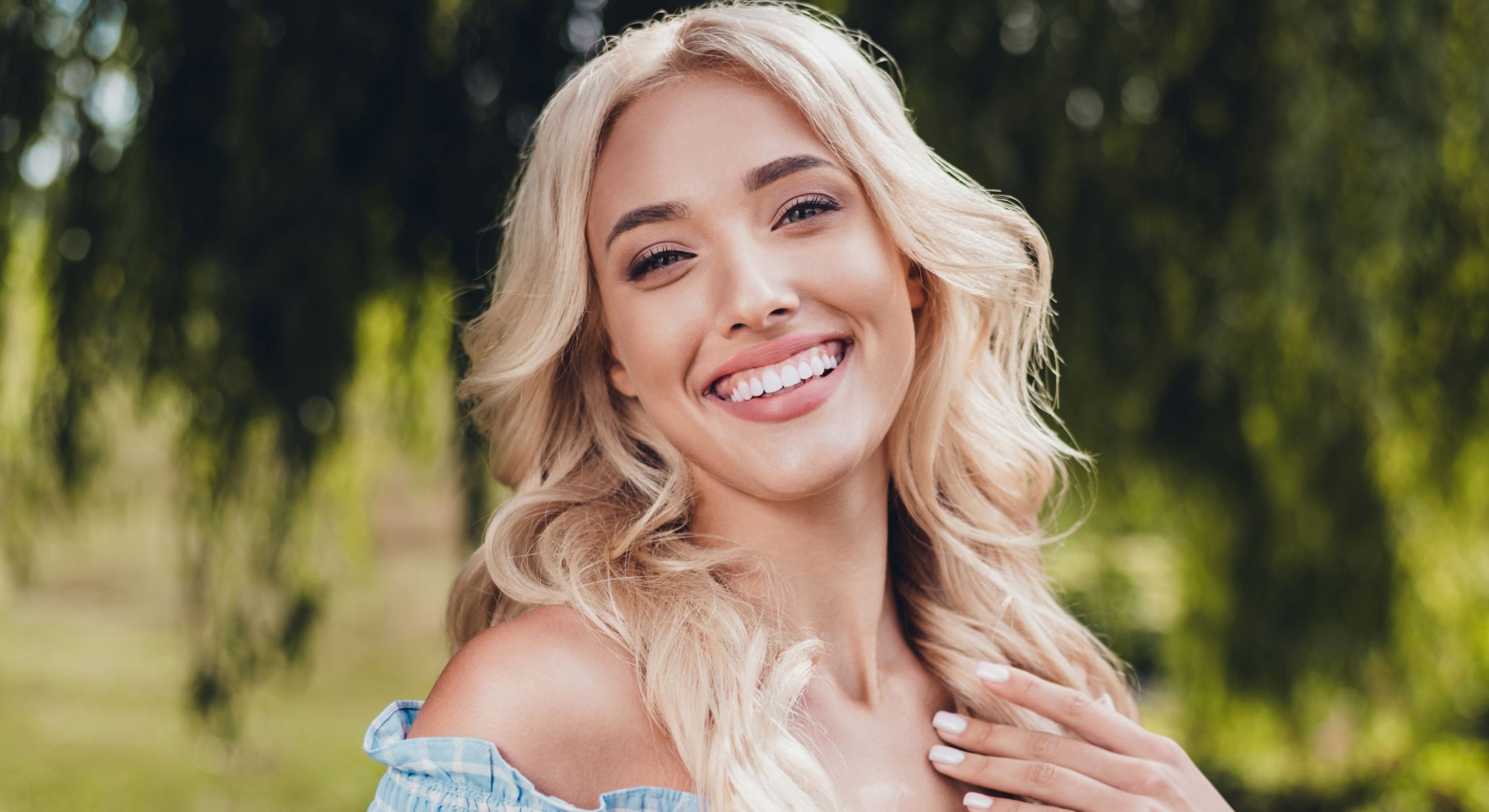 Smiling woman outdoors with long blonde hair