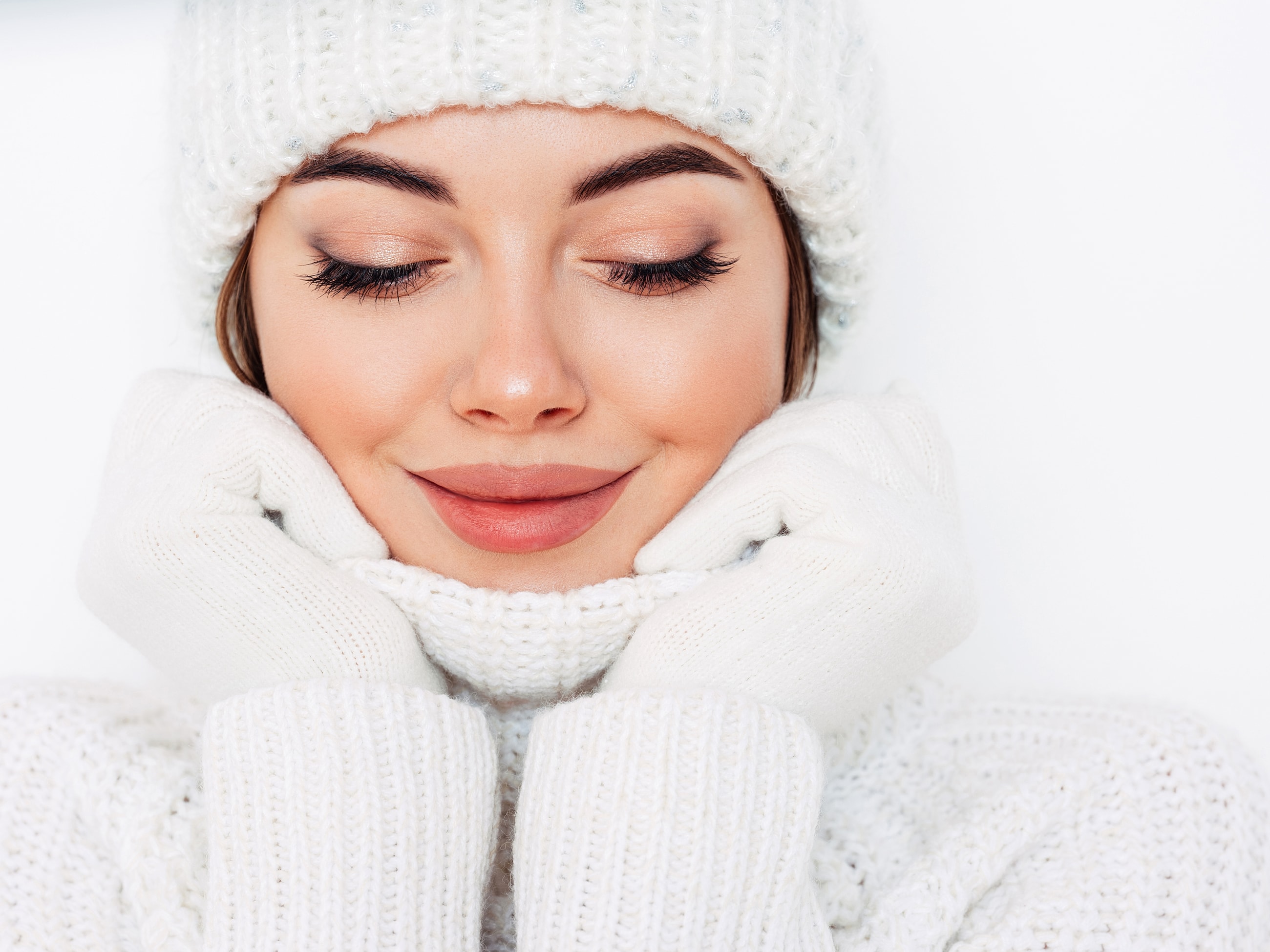 Woman in winter attire smiling warmly.